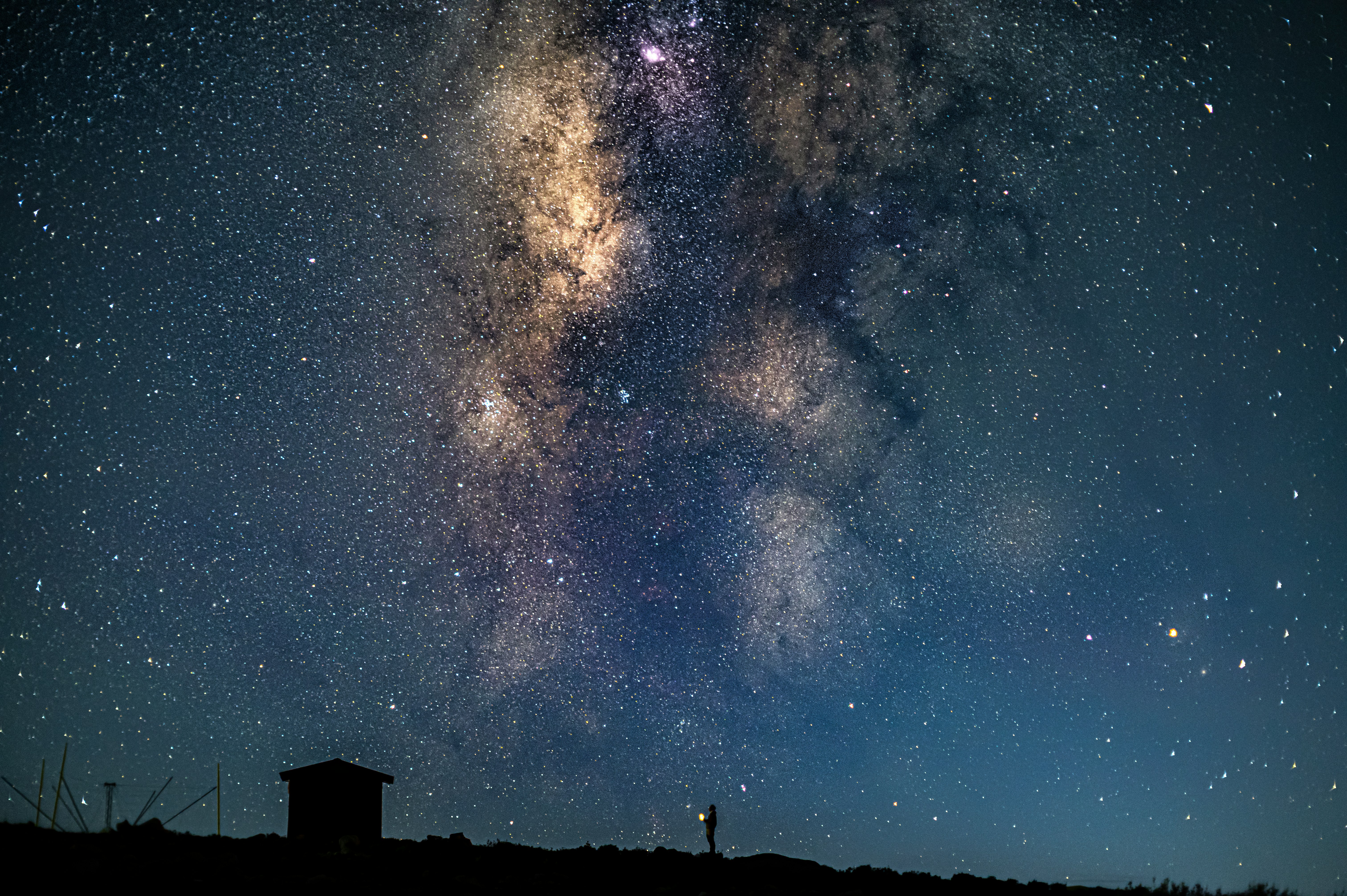 silhouette of house under starry night